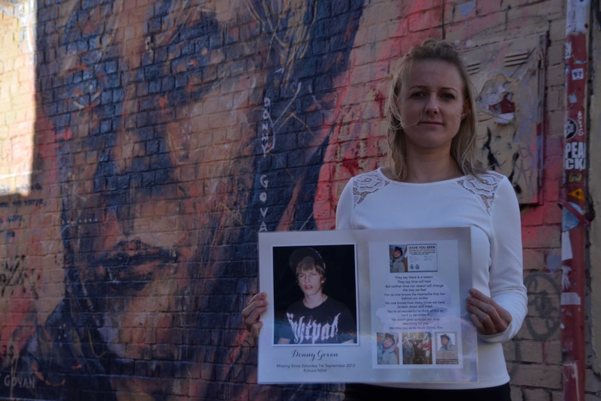 Rachael holds a poster in memory of Donny
