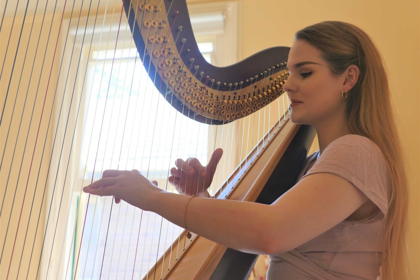 Harpist and Wiradjuri woman Kaela Phillips players her harp.