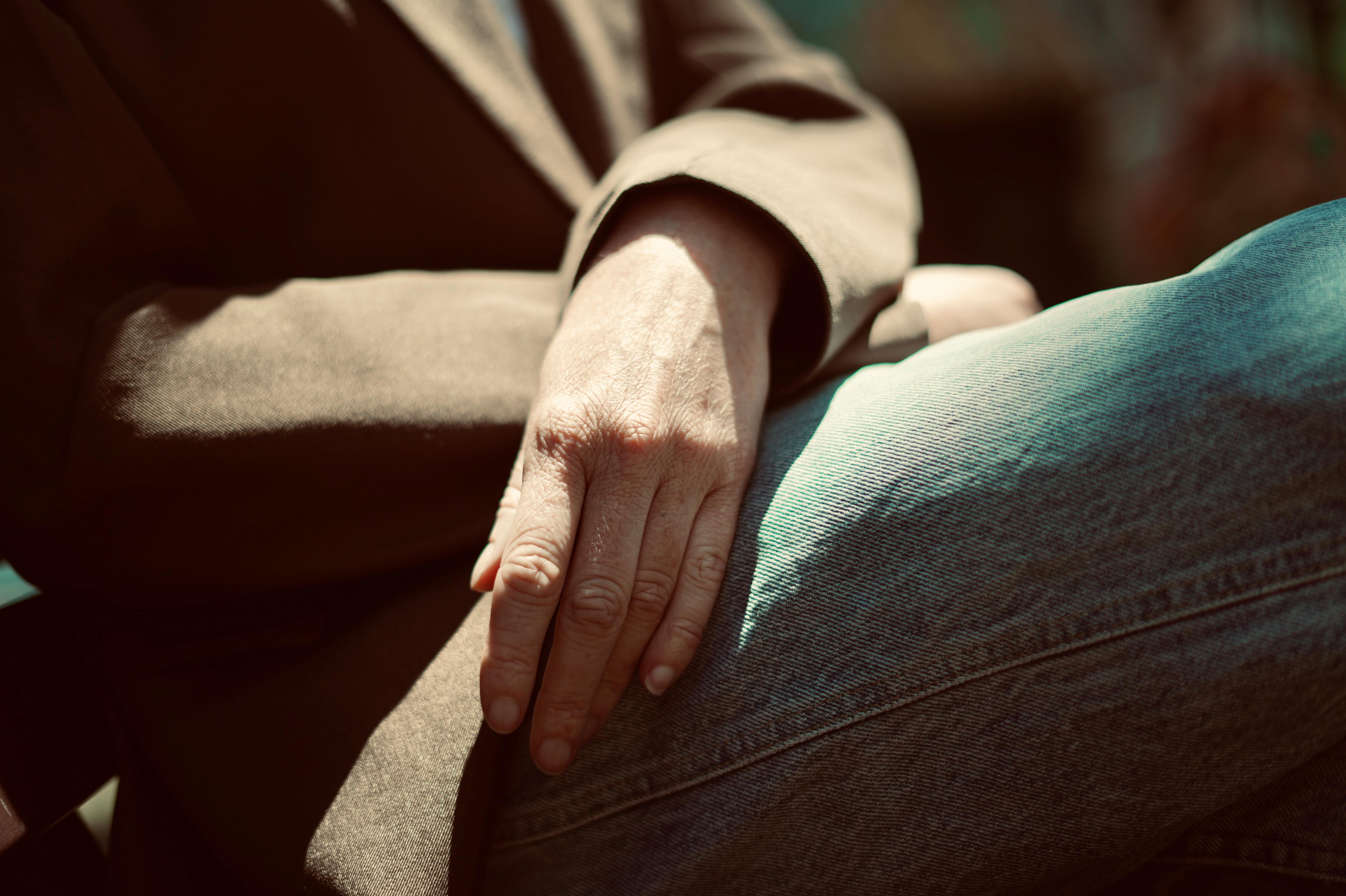 Close up of hands and legs of a lady sitting. 