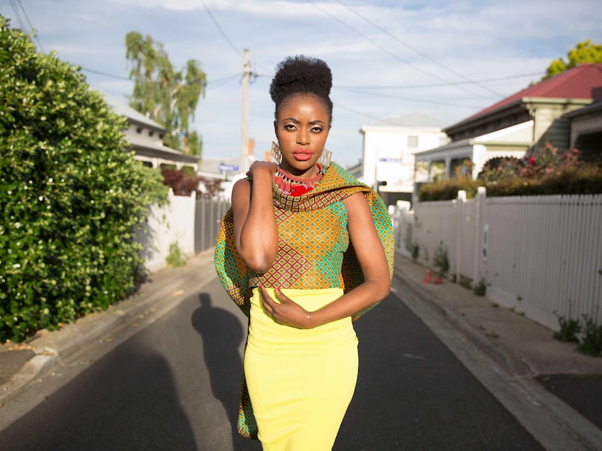 Phoebe Mwanza wearing a colourful cape and yellow pencil skirt