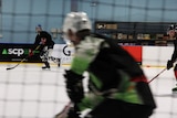 Three players on the rink moving at high speed.