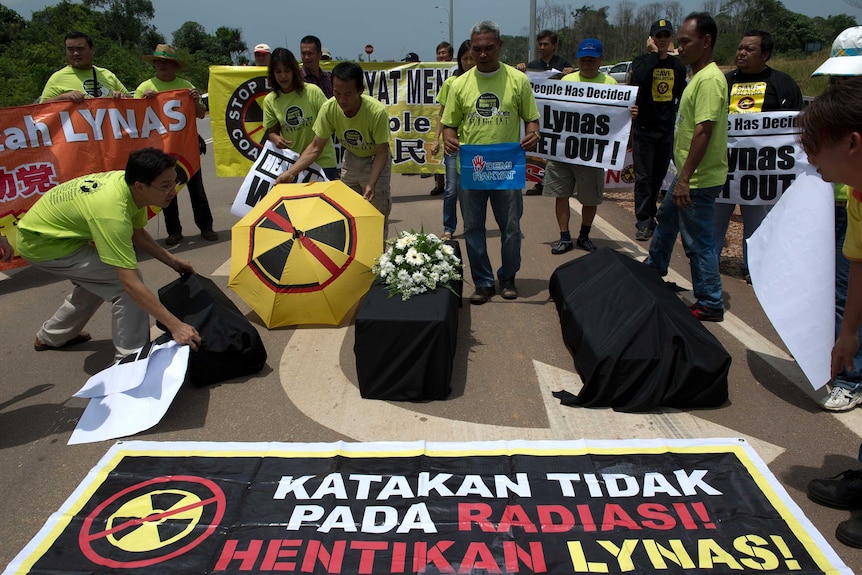 Protesters on the street with three symbolic coffins.