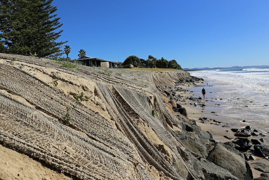 Rocks and netting exposed by erosion between house and beach at Belongil in Byron Bay