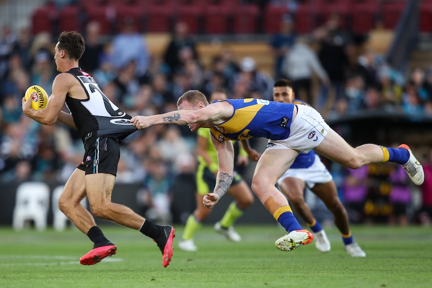 Connor Rozee of the Power is tackled by Bailey J. Williams of the Eagles