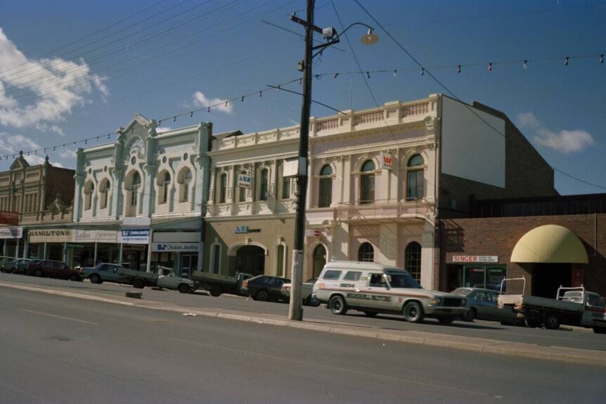 An old photograph of Kalgoorlie's main street in 1985 showing old buildings and a panel van.