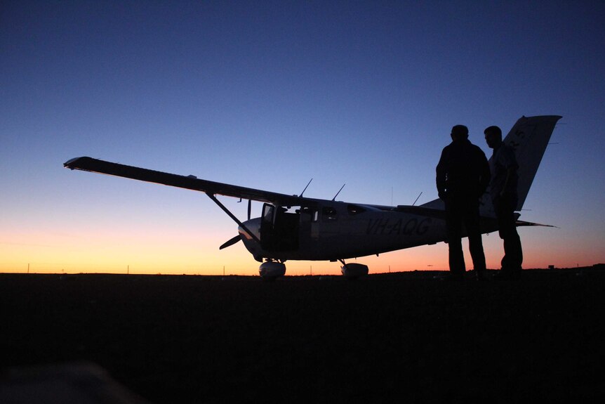 Professor Richard Kingsford at dawn next to a plane, 2016.