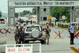 Pakistani security personnel block a road linked to the Kamra air base in Kamra.