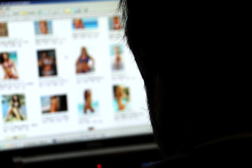 Anonymous man views blurred photos of women on a computer screen.
