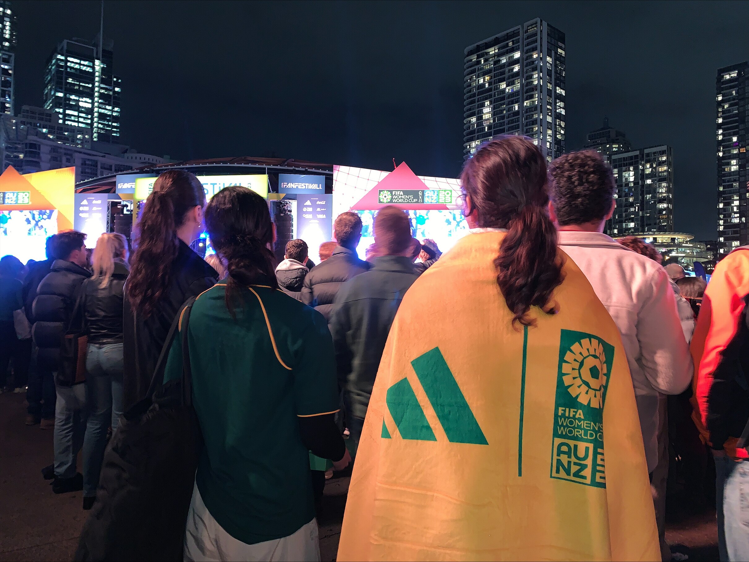 the back of a football fan draped in a matildas football team flag
