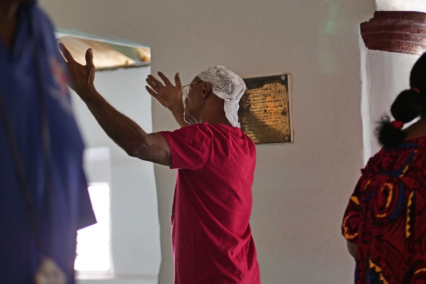 man in red shirt with his hands raised