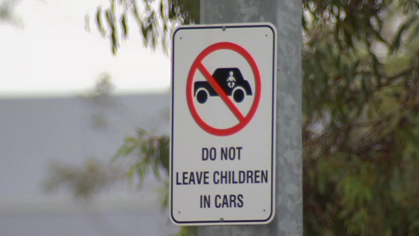 A sign warning people not to leave their children alone in parked cars.
