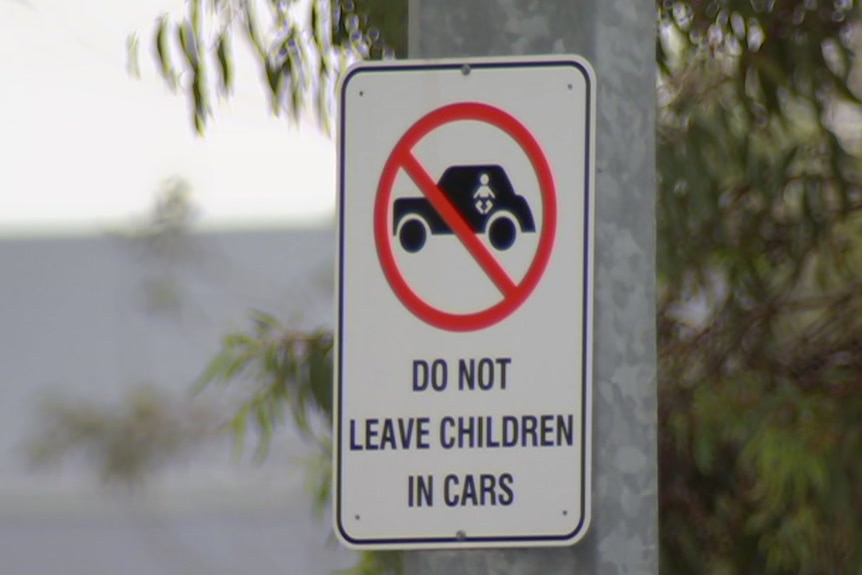 A sign warning people not to leave their children alone in parked cars.