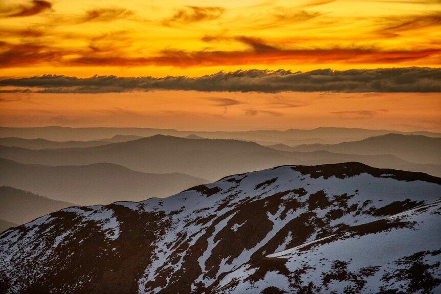 mountain tops dusted with snow during a spectacular sunset.