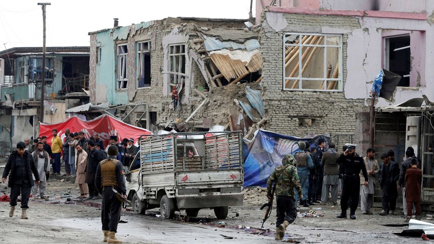 Afghan police officers inspect the site of a car bomb attack in Kabul.