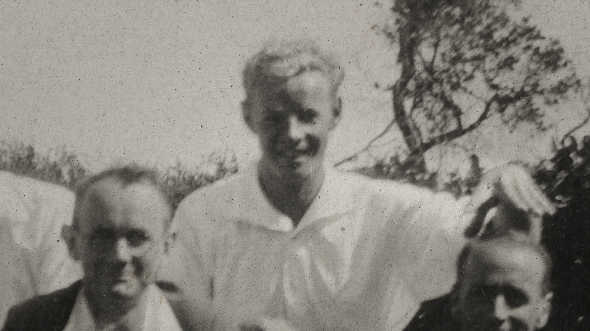 A black and white photo of a man in a white collared shirt, 1921