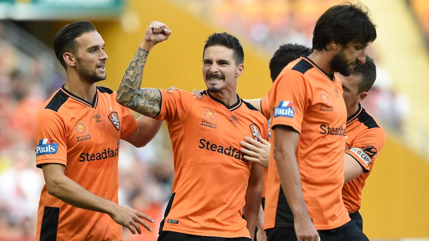Brisbane Roar players surround Jamie MacLaren after goal against Glory