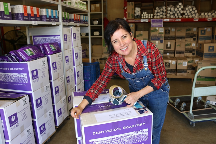 Rebecca Zentveld taping up a box of coffee packs.