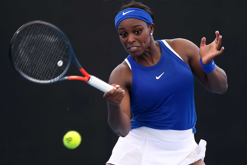 Sloane Stephens, wearing a blue singlet, plays a forehand shot in a tennis match.