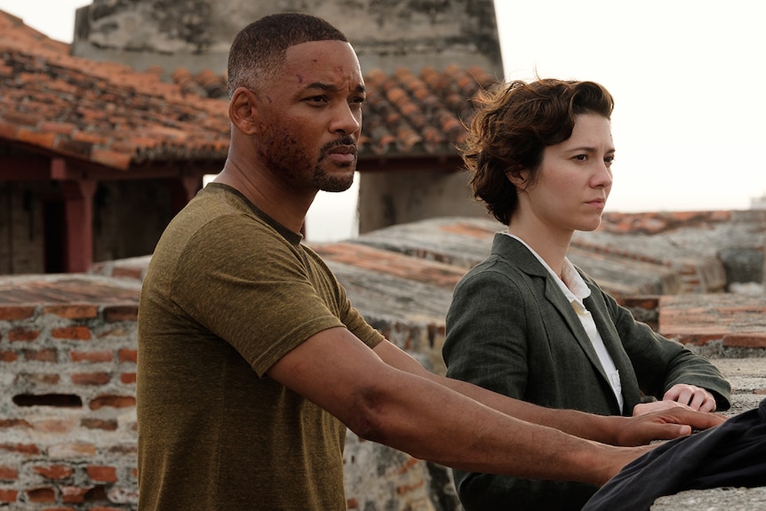 Will Smith (left) and Mary Elizabeth Winstead look off into distance from a bricked and tiled rooftop.