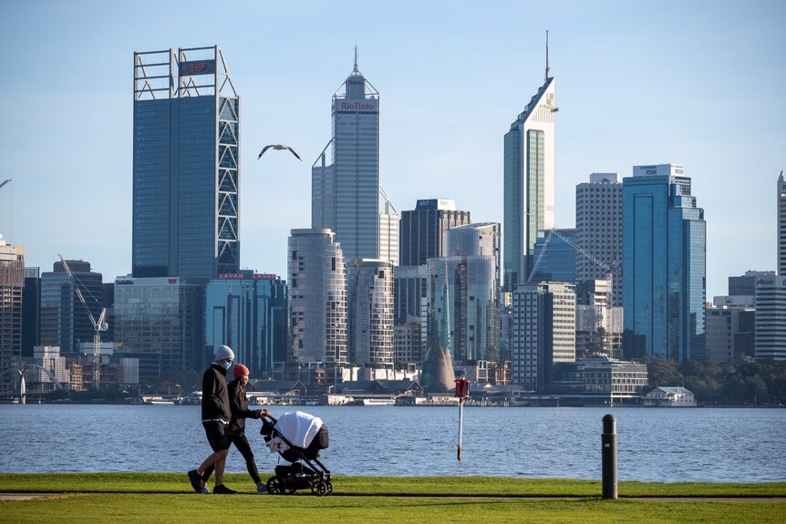 A man and a woman with a pram walk along the South Perth foreshore.