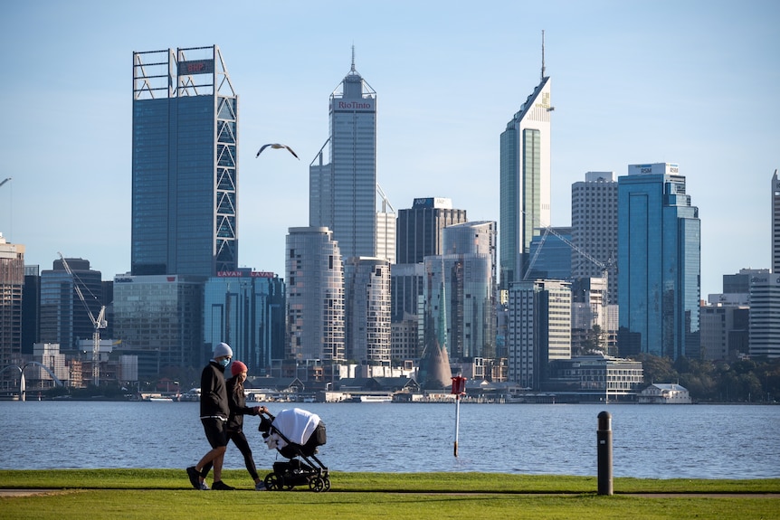 A man and a woman with a pram walk along the South Perth foreshore.