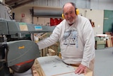 Ulverstone Men's Shed member Len Blair stands at a drop saw in the Ulverstone Men's Shed.