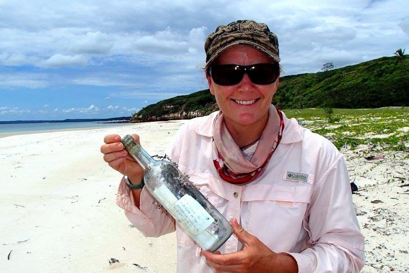 Bamaga police sergeant Suzie MacDonald holds the message-containing-bottle she and her colleagues found on a remote beach.