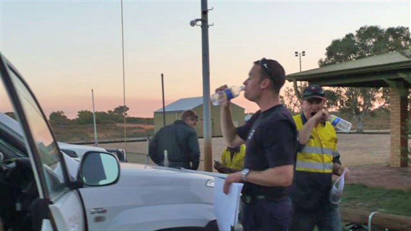 Exhausted volunteers take a break from fighting the Eneabba fire