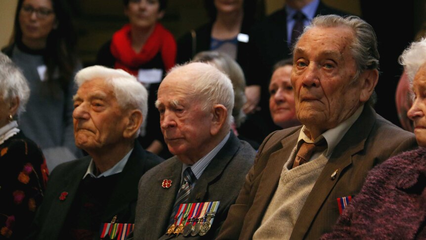 Three veterans during a ceremony.