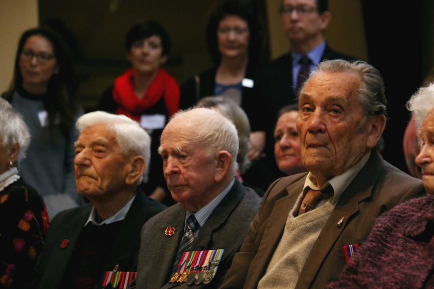 Three veterans during a ceremony.