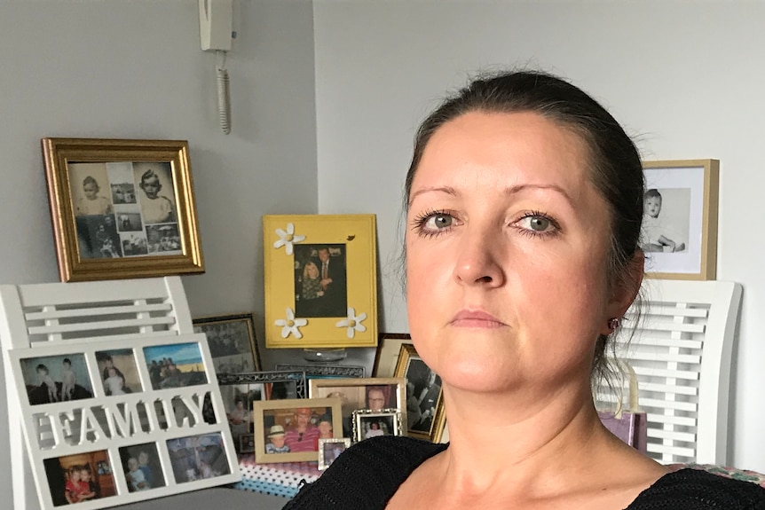 Nikki Hodson sits in a room in her house, surrounded by family photographs.