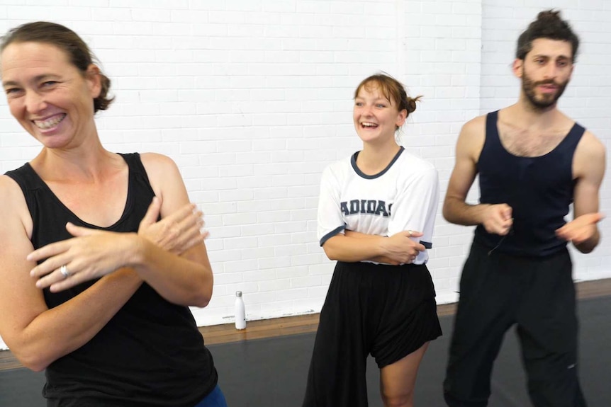 Informal grouping of three dancers standing around laughing and talking