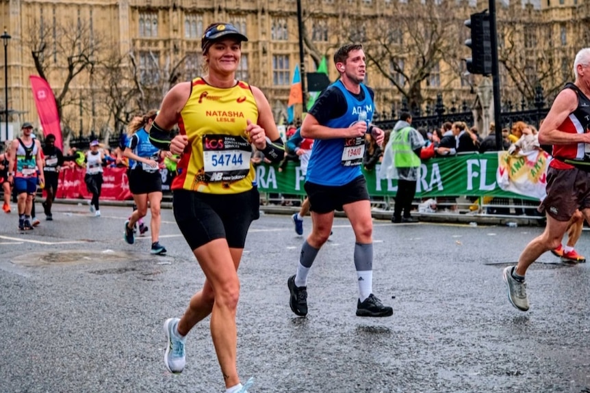 A woman runs in the London Marathon under Big Ben.