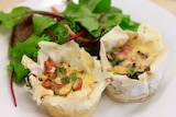 Close-up of minis quiches served with lettuce on a white plate