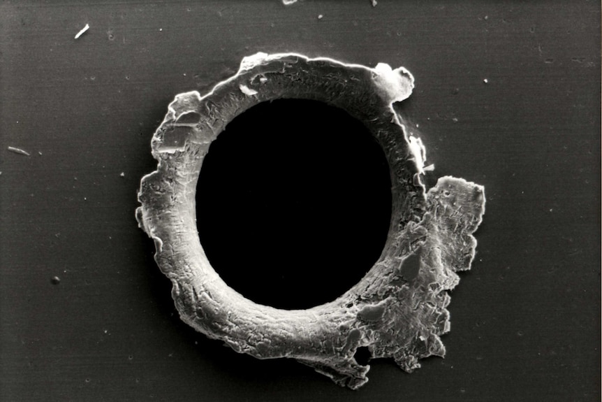 A black and white image of a puncture mark in equipment.