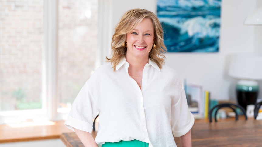 Sales standing in a dining room, smiling at camera.