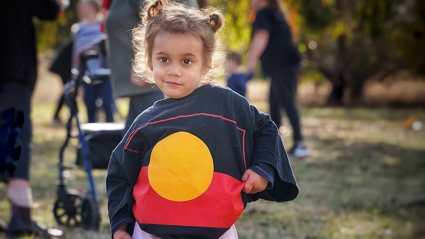 Little indigenous girl wearing the Aboriginal Flag on a jumper as part of NAIDOC Week celebrations, 8th July 2019