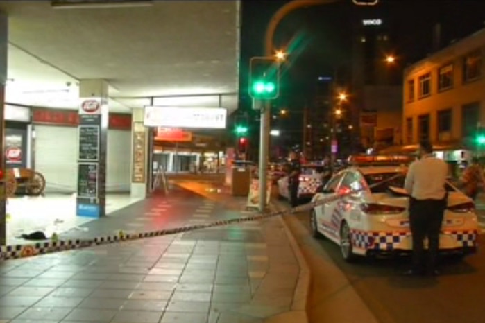 Police tape and officers at scene of a fatal stabbing on Surfers Paradise Boulevard.