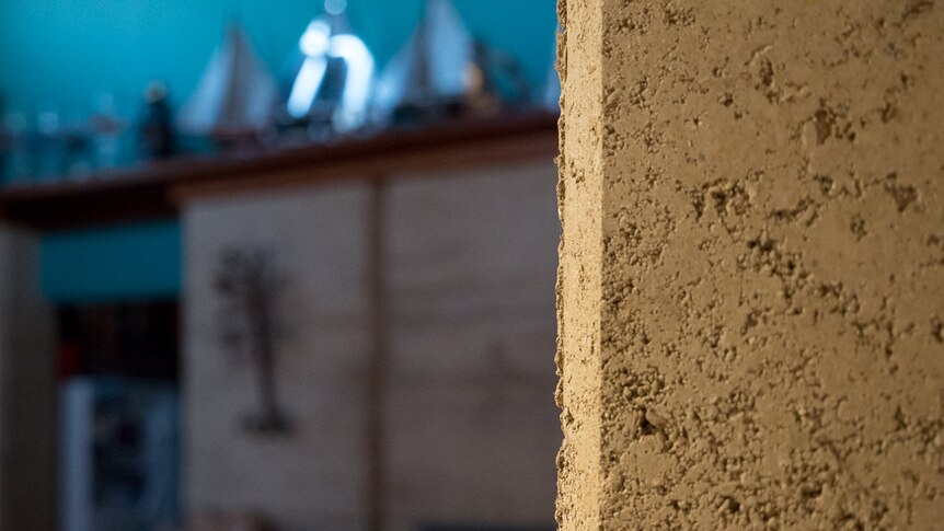 A two-storey rammed-earth wall runs through the centre of the home.