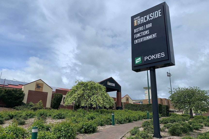 The exterior of a large, modern building with a sign at the front.