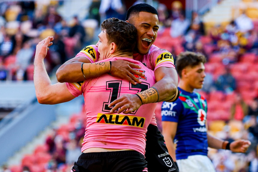 Two Penrith NRL players embrace as they celebrate a try against the Warriors.