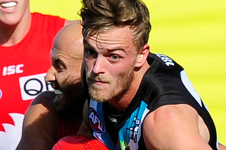 John McCarthy of Port Adelaide breaks a tackles during a match against the Sydney Swans.