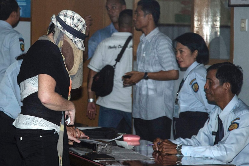 Convicted drug smuggler Schapelle Corby has her fingerprint taken as she leaves prison.