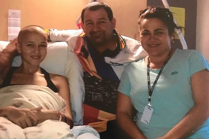 sick girl in hosptial bed with her father and mother