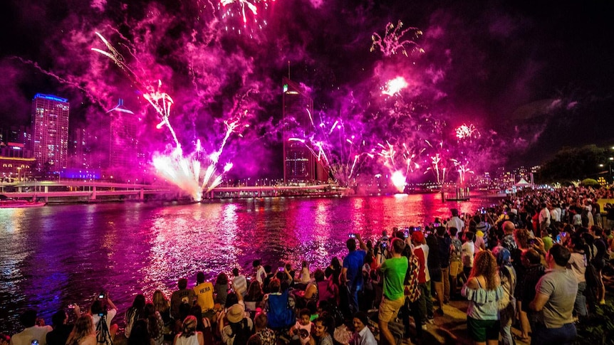 People watch fireworks on New Year's Eve over the Brisbane River at South Bank on December 31, 2018.