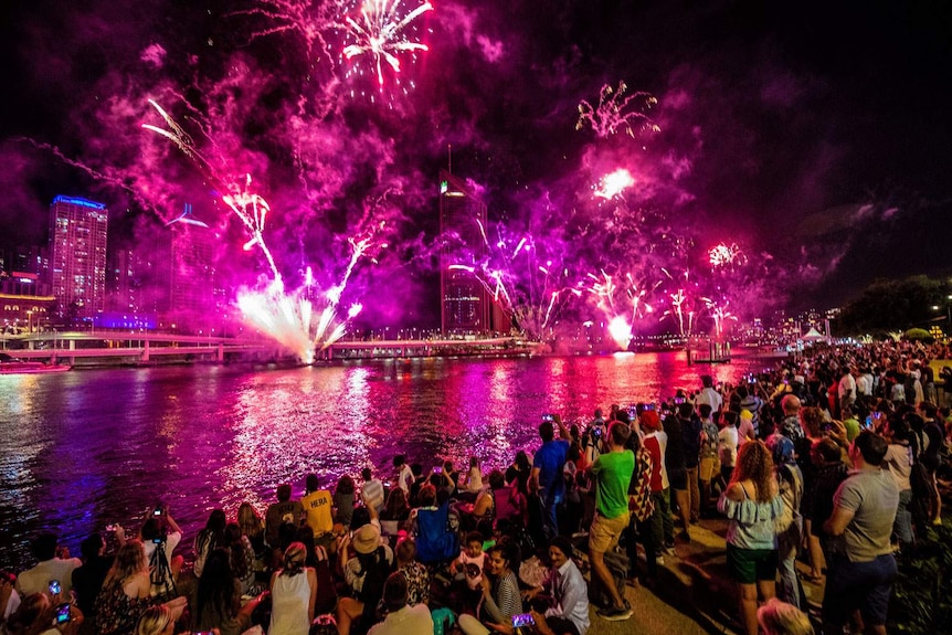 People watch fireworks on New Year's Eve over the Brisbane River at South Bank on December 31, 2018.