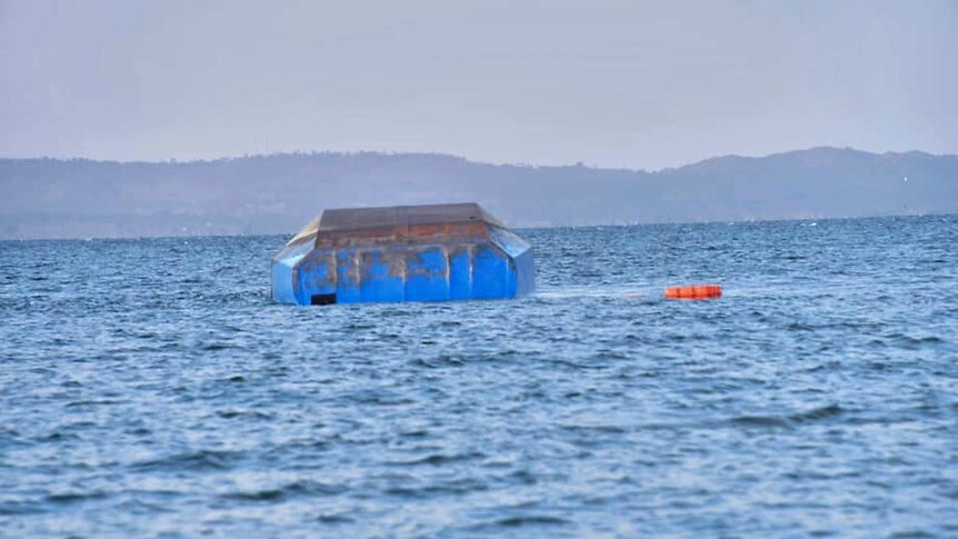 The upturned passenger ferry MV Nyerere floats in the water