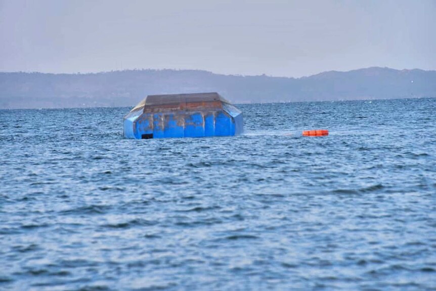 The upturned passenger ferry MV Nyerere floats in the water