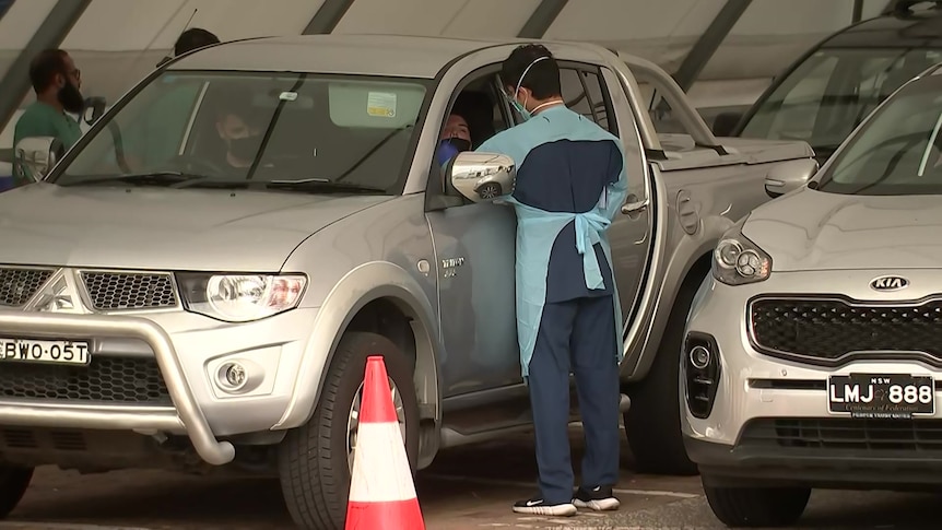 a health care worker next to a car