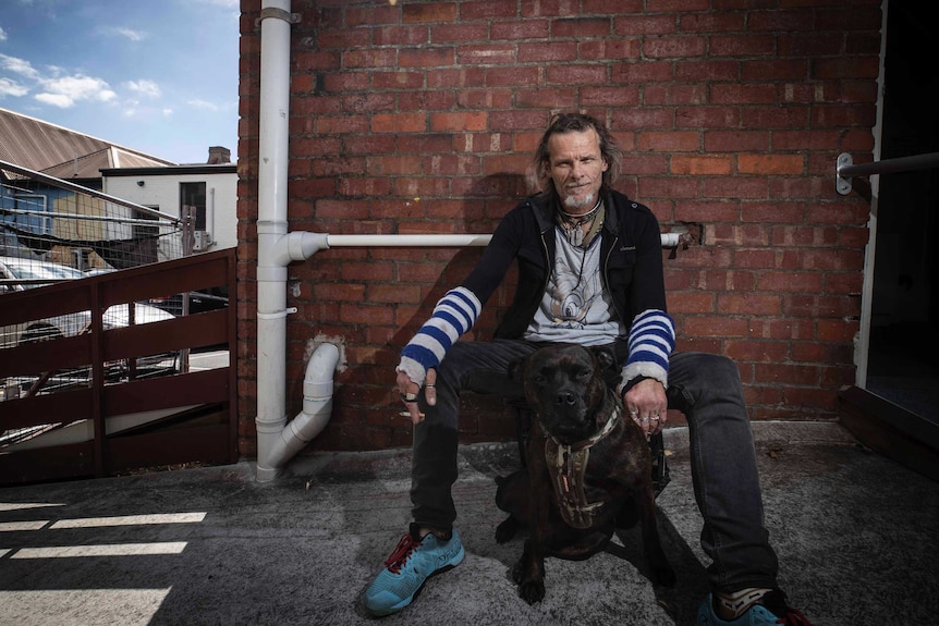 Judd Nicholls with his dog Grinna at Hobart's Safe Space homeless facility.